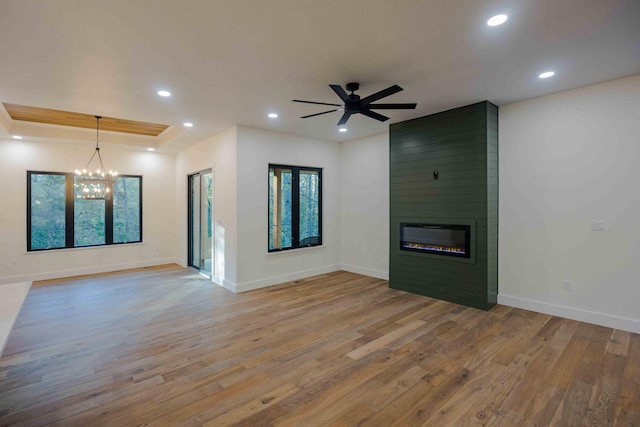 unfurnished living room with baseboards, recessed lighting, wood finished floors, and a large fireplace