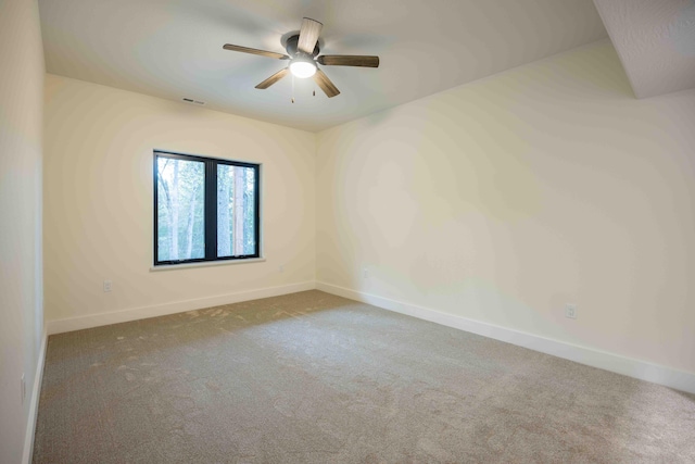 spare room with visible vents, a ceiling fan, baseboards, and carpet floors