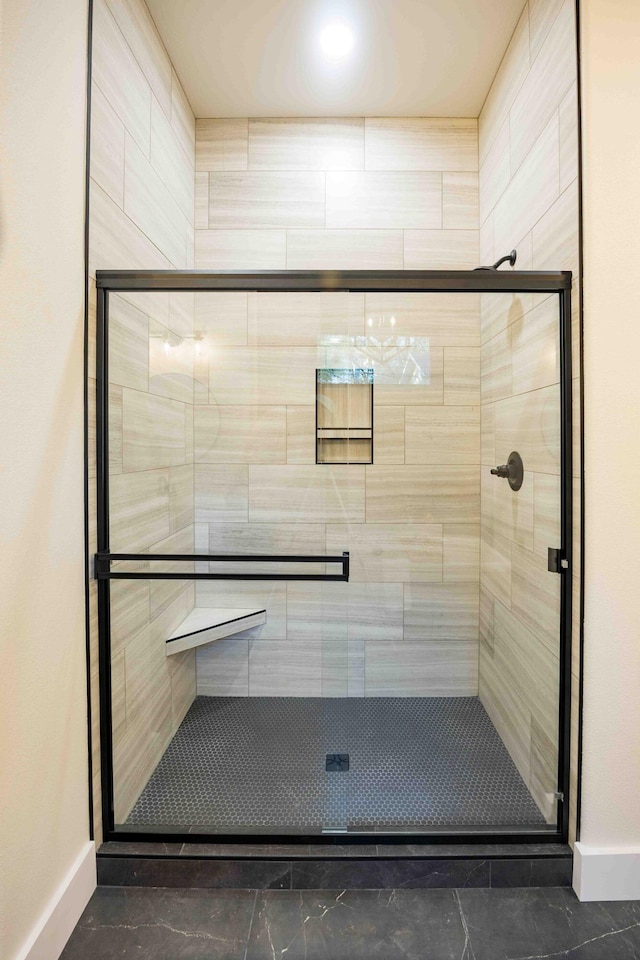bathroom featuring baseboards and a shower stall