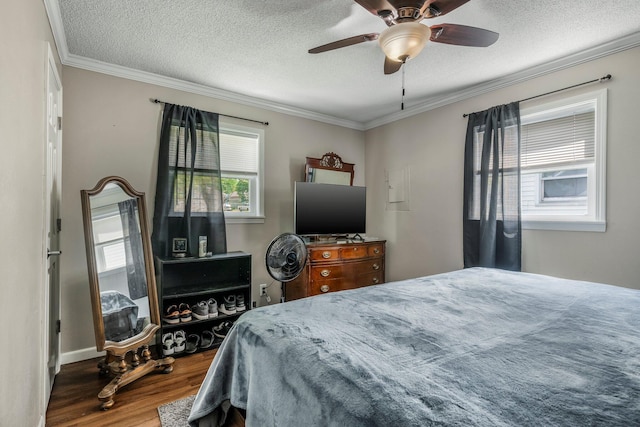 bedroom with crown molding, a textured ceiling, a ceiling fan, and wood finished floors