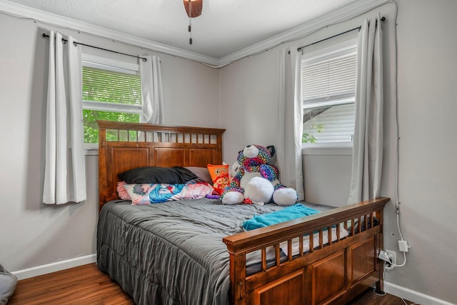 bedroom with crown molding, baseboards, ceiling fan, and wood finished floors