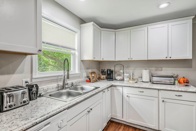 kitchen featuring a sink, dishwasher, white cabinetry, wood finished floors, and a toaster