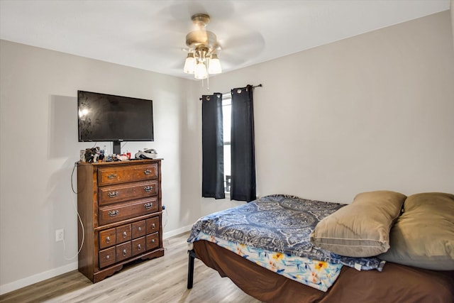 bedroom with light wood-style floors, baseboards, and a ceiling fan