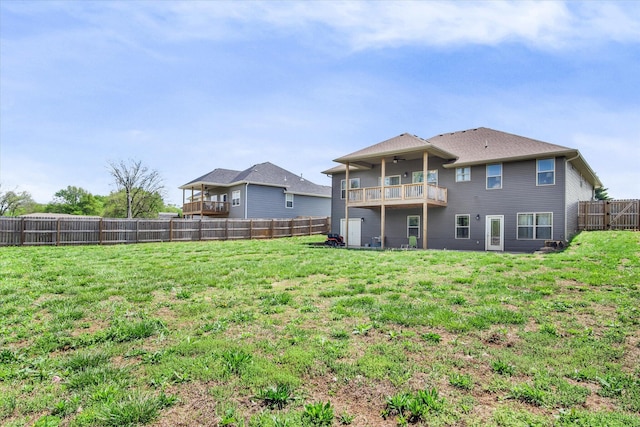 back of property featuring a ceiling fan, a fenced backyard, and a yard