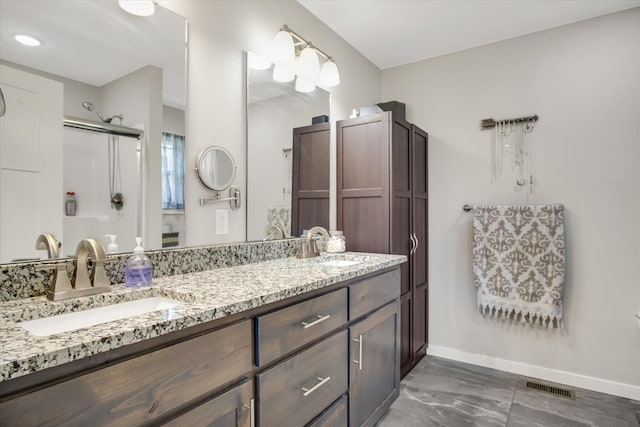 full bathroom with visible vents, marble finish floor, baseboards, a shower stall, and a sink