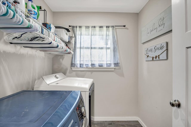 clothes washing area with laundry area, baseboards, and washing machine and dryer
