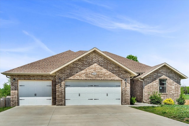 view of front of house with brick siding, a garage, a shingled roof, and concrete driveway