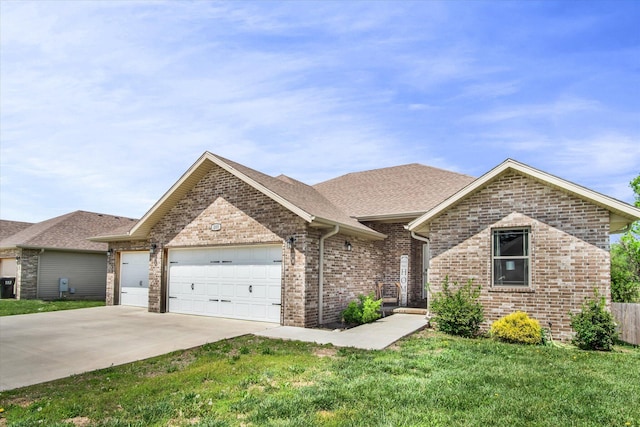 view of front of property with roof with shingles, a front lawn, brick siding, a garage, and concrete driveway