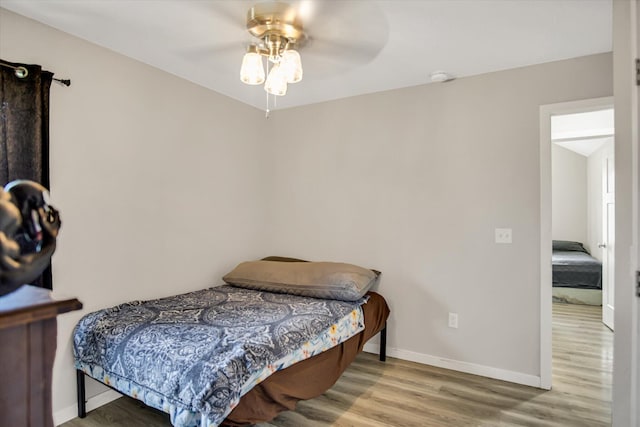 bedroom with baseboards, ceiling fan, and wood finished floors