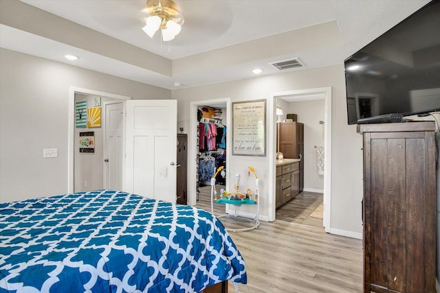 bedroom featuring visible vents, baseboards, a closet, light wood finished floors, and a spacious closet