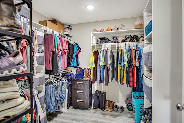 walk in closet with wood finished floors