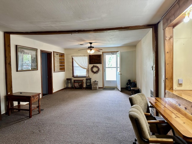 interior space featuring baseboards, a ceiling fan, and beam ceiling