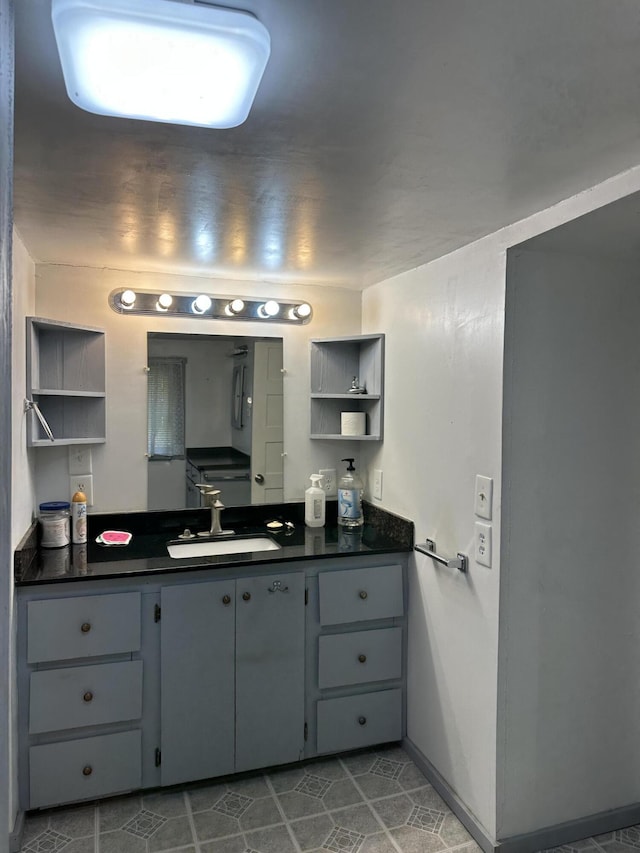 bathroom featuring baseboards, tile patterned flooring, and vanity