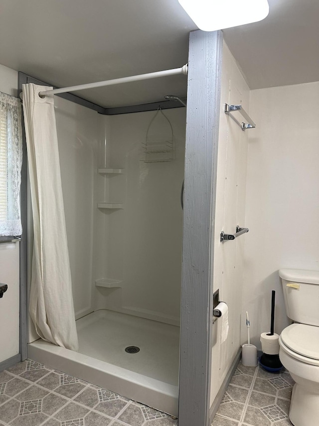 full bath with tile patterned floors, a stall shower, and toilet