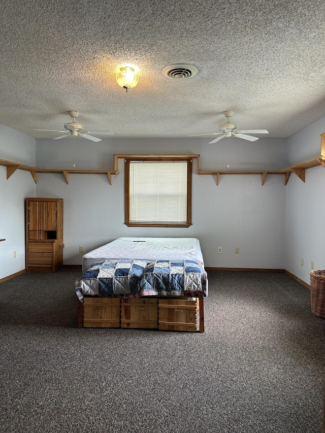 bedroom with carpet floors, a textured ceiling, baseboards, and visible vents