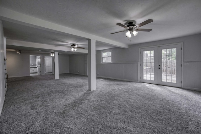below grade area with french doors, carpet, and ceiling fan