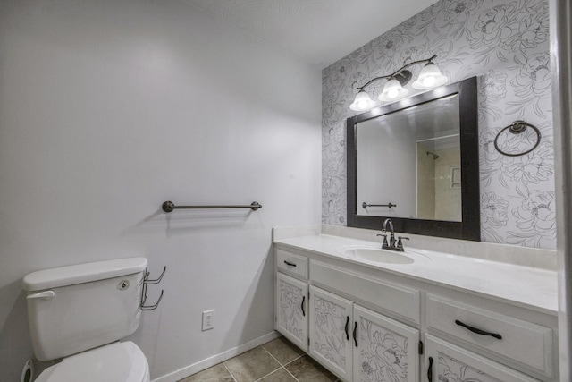 bathroom with vanity, a shower, toilet, baseboards, and wallpapered walls