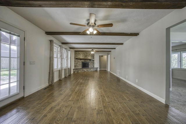unfurnished living room featuring visible vents, a ceiling fan, dark wood-style floors, and beamed ceiling