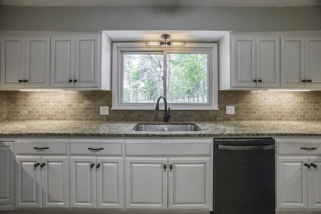 kitchen featuring a sink, backsplash, black dishwasher, and white cabinetry
