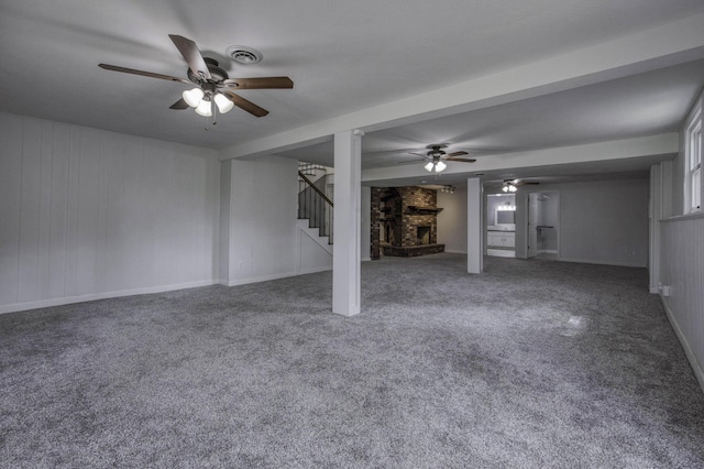 unfurnished living room with visible vents, a brick fireplace, ceiling fan, stairway, and carpet