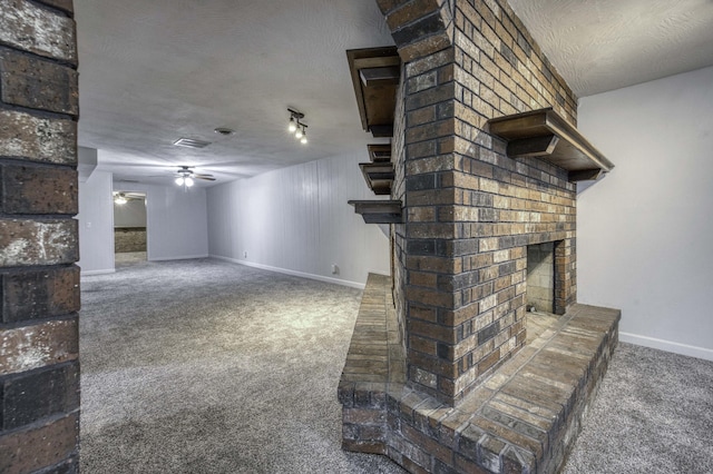 unfurnished living room with a ceiling fan, visible vents, a fireplace, baseboards, and carpet