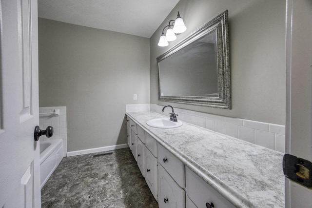 full bathroom with vanity, baseboards, and a bathing tub