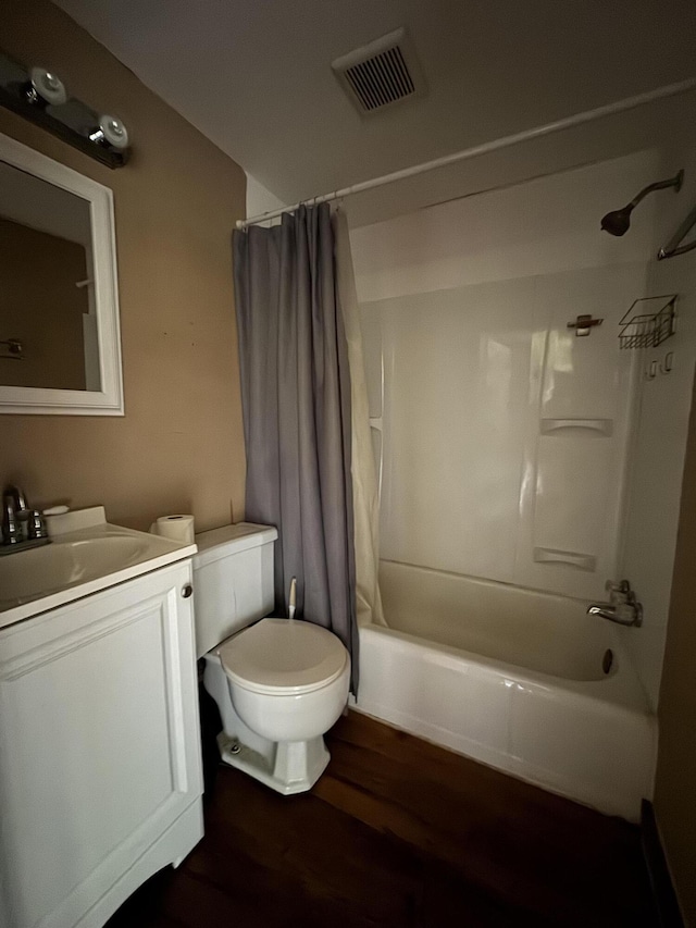 bathroom featuring visible vents, vanity, shower / bath combo with shower curtain, wood finished floors, and toilet