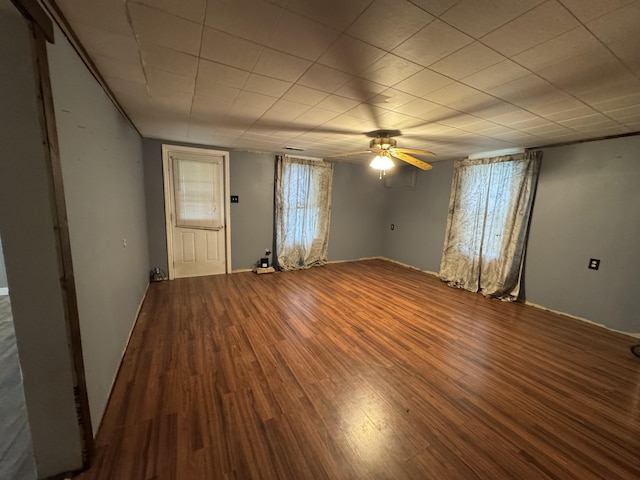 spare room with ceiling fan, plenty of natural light, and wood finished floors