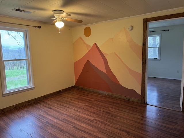 unfurnished room featuring visible vents, ornamental molding, wood finished floors, baseboards, and a ceiling fan