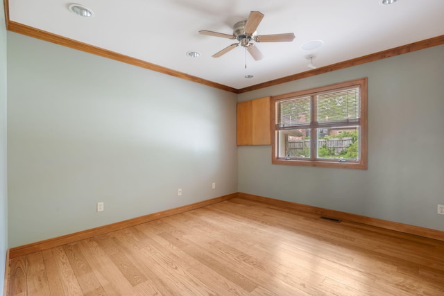spare room with crown molding, visible vents, baseboards, ceiling fan, and light wood-style flooring
