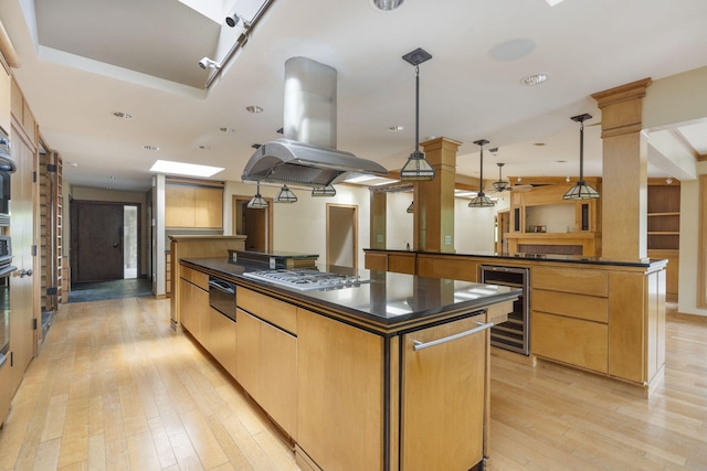 kitchen with beverage cooler, dark countertops, a spacious island, and stainless steel gas stovetop