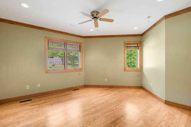 spare room with crown molding, plenty of natural light, visible vents, and ceiling fan