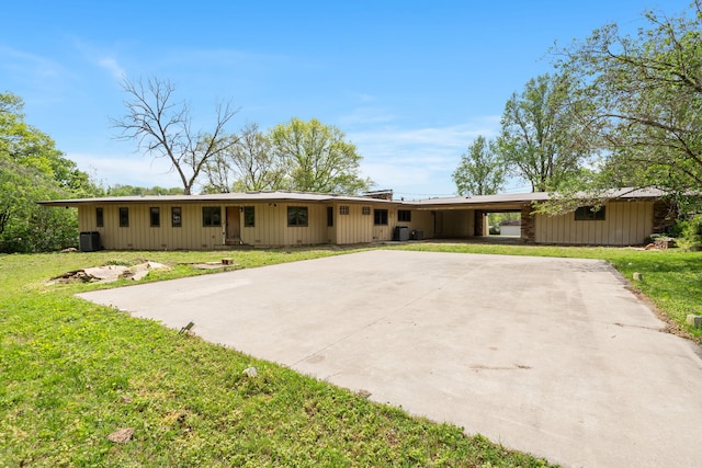 single story home featuring driveway, cooling unit, a carport, and a front lawn
