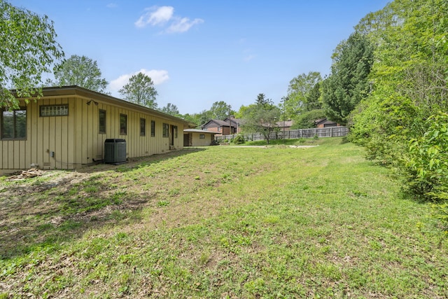 view of yard featuring fence and central AC