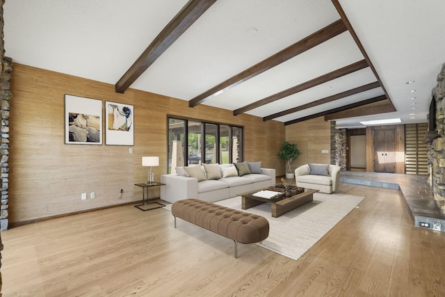 living area with ornate columns, wood walls, vaulted ceiling with beams, and light wood-type flooring
