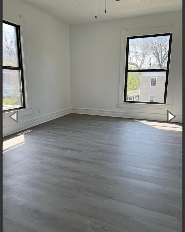 empty room with baseboards, ceiling fan, and wood finished floors