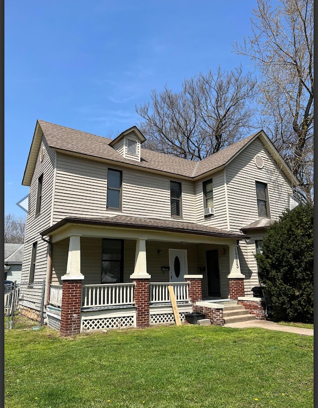 view of front of house featuring a porch, a shingled roof, and a front yard