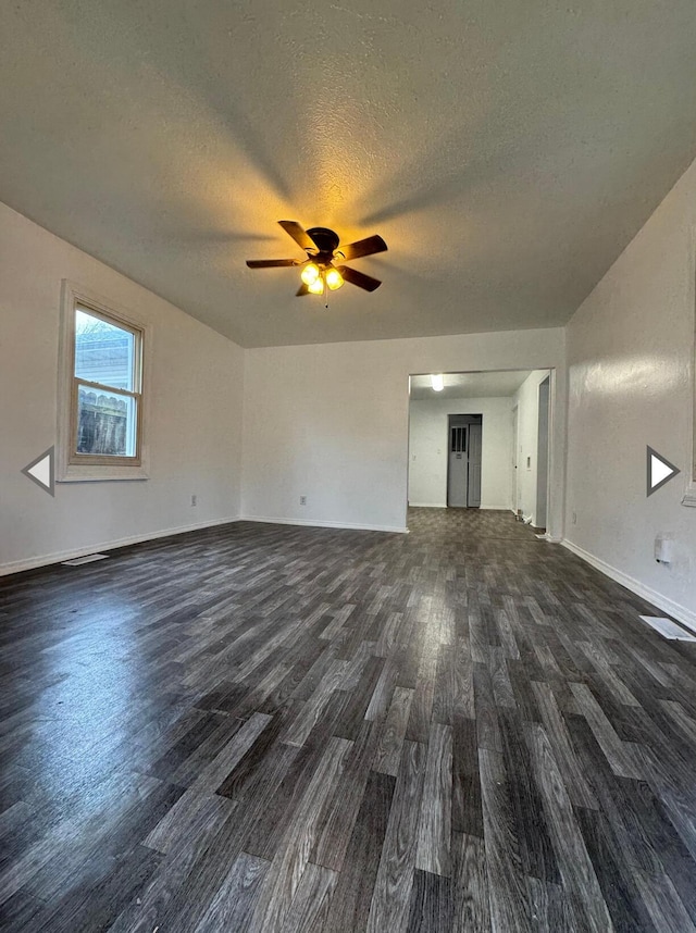 2105 N Elizabeth Ave, Springfield, MO 65803 - unfurnished living room featuring baseboards, a ceiling fan, dark wood-style flooring, and a textured ceiling