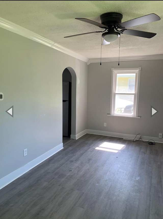 unfurnished room with dark wood-style flooring, arched walkways, a textured ceiling, a ceiling fan, and ornamental molding