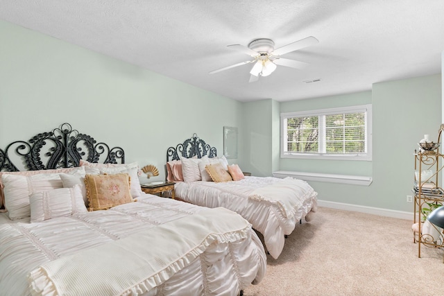 bedroom with carpet flooring, ceiling fan, a textured ceiling, baseboards, and visible vents