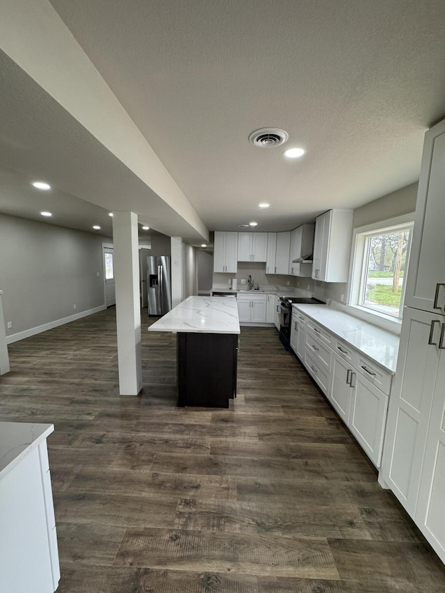 1256 Black Oak Resort Ln, Lampe, MO 65681 - kitchen with dark wood-style flooring, light stone countertops, a center island, black electric range, and stainless steel fridge with ice dispenser