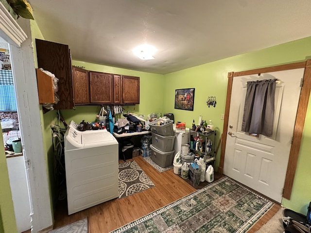 laundry room with cabinet space, washer / dryer, and light wood finished floors