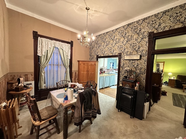 carpeted dining room featuring crown molding, an inviting chandelier, wainscoting, and radiator