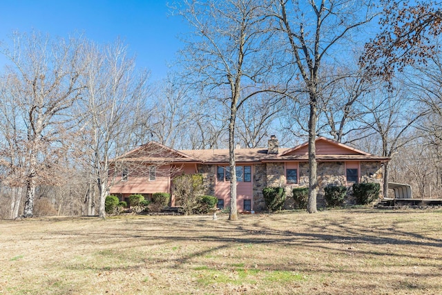 view of front of home with a chimney, stone siding, and a front yard