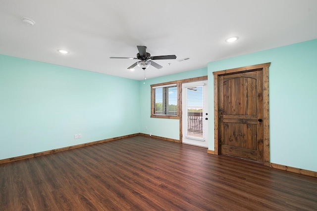 spare room with dark wood-style flooring, baseboards, and ceiling fan