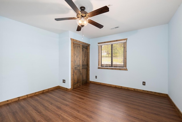 unfurnished room featuring baseboards, ceiling fan, wood finished floors, and visible vents