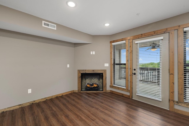 unfurnished living room with visible vents, a fireplace, wood finished floors, baseboards, and recessed lighting