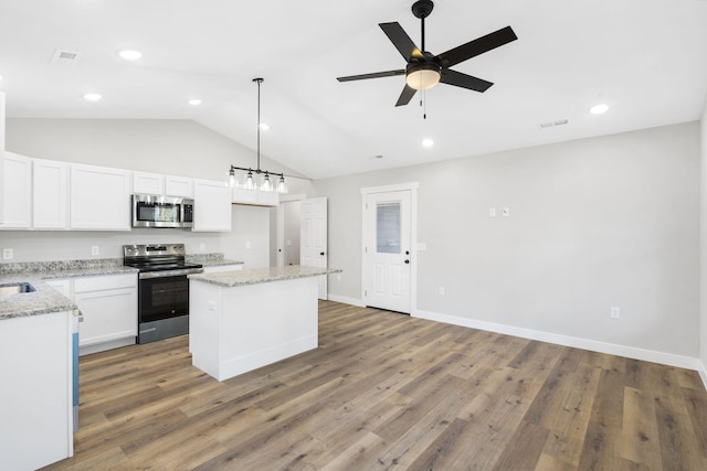 kitchen with a ceiling fan, appliances with stainless steel finishes, a center island, wood finished floors, and white cabinets