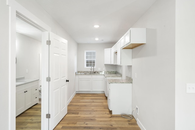 kitchen featuring light wood-style floors, white cabinets, light stone countertops, and recessed lighting
