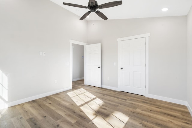 unfurnished bedroom with a ceiling fan, baseboards, high vaulted ceiling, light wood-style floors, and recessed lighting